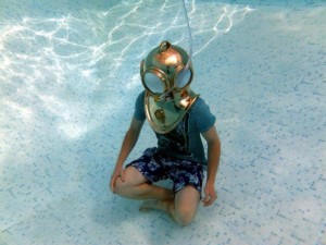 Photo of diver trying out a brass helmet